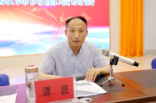 图四：教体局普教股股长谭波宣读《关于进一步加强潢川县中小学心理健康教育工作的意见》.JPG